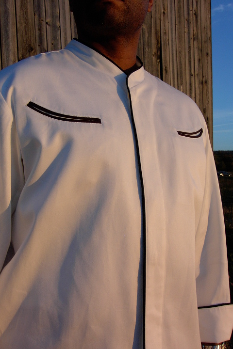Chef Coat Style CBM103H: Shown in white, 100% cotton Supima gabardine, left & right chest curved double welt pockets, & black piping (collar, front, pocket & cuffs).