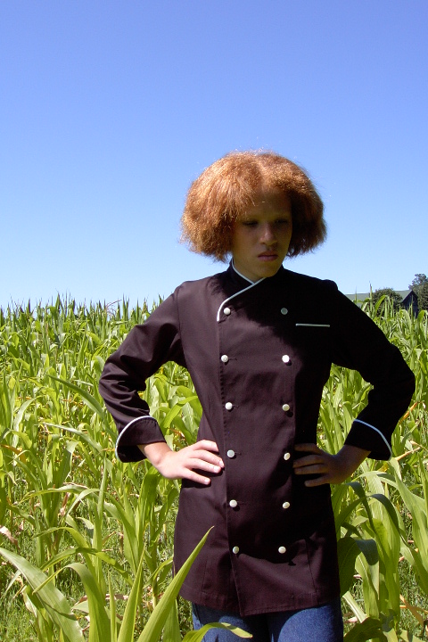 Women's Chef Coat Style CBW101: Shown in Black, 100% Cotton Supima gabardine, natural white piping (collar, pocket & cuffs), left chest tailored welt pocket & faux mother-of-pearl buttons.