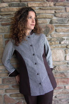 Women's Chef Coat Style CBW104: Shown in white & black plaids & checks & black cuffs, collar & side panels, 100% cotton Supima Gabardine, snow white piping (collar & cuffs) & hand tied knot buttons.